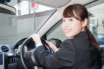 車で外回り営業をする女性