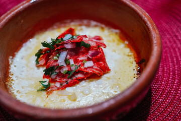 Delicious grilled cheese with chorizo, onion and cilantro in clay pot