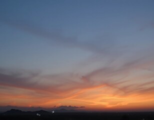 Obraz premium Serene Sunset Over Distant Mountain Silhouette