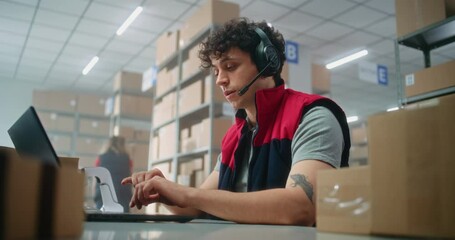 Customer support specialist in logistics wearing headset talks to customer on call, uses laptop, works in post office or online store storage. Sorting center workers carrying cardboard boxes. Handheld