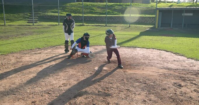 Playing baseball, batter running to first base while catcher and umpire watch