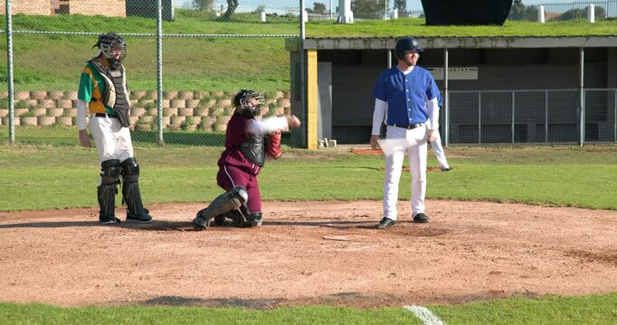 Playing baseball, batter adjusting helmet while catcher and umpire watch attentively