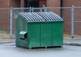 large green commercial dumpster for trash and recycling