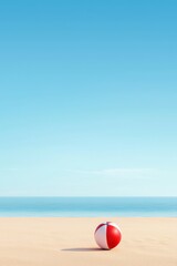 Obraz premium Vibrant Beach Scene with Red and White Beach Ball on Serene Sand and Clear Blue Sky Overlooking Calm Ocean Water in a Summer Landscape