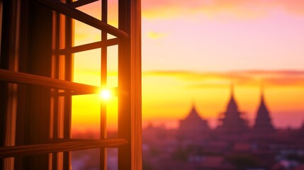 A sunset view through a window, highlighting silhouettes of buildings and a warm atmosphere.