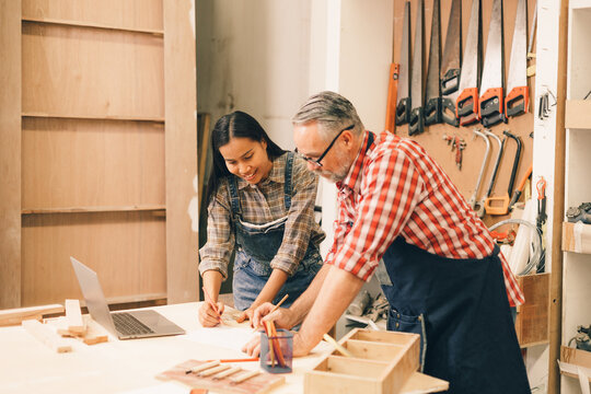 Professional carpenter man working with wood piece design furniture in workshop in wood factory