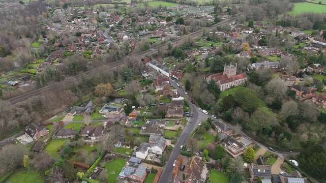 Aerial overview of a closely knit suburban area with red-roofed homes, scattered trees, and organically shaped roads, reflecting intimate community living