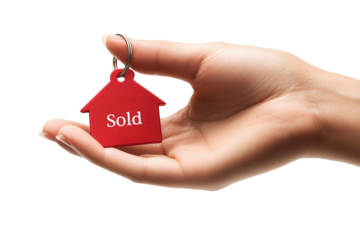 Sold house keychain held in a hand.