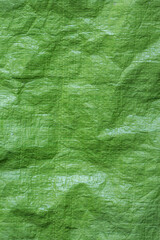 Green tarpaulin waterproof sheet background. Versatile material used in construction, gardening and camping.