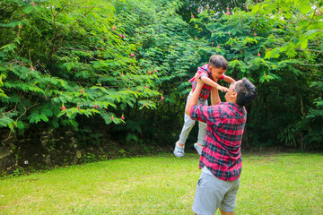 Obraz premium Asian father in casual clothes have walk and fun with daughter outdoors near forest.
