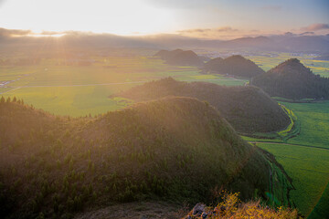 Beautiful sharp 90 degrees triangular shape rocks in line surrounded by vast canola fields in...