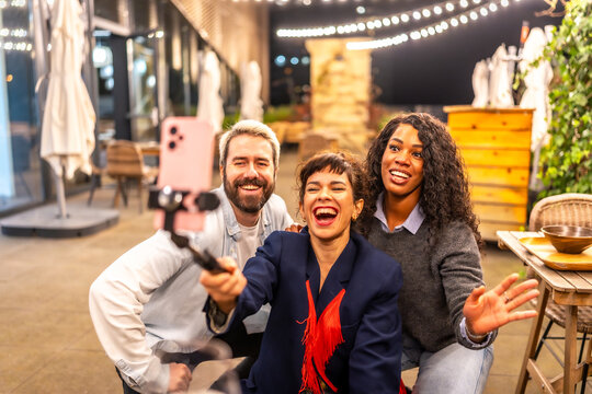 Vlogger laughing with friends celebrating night party recording new video