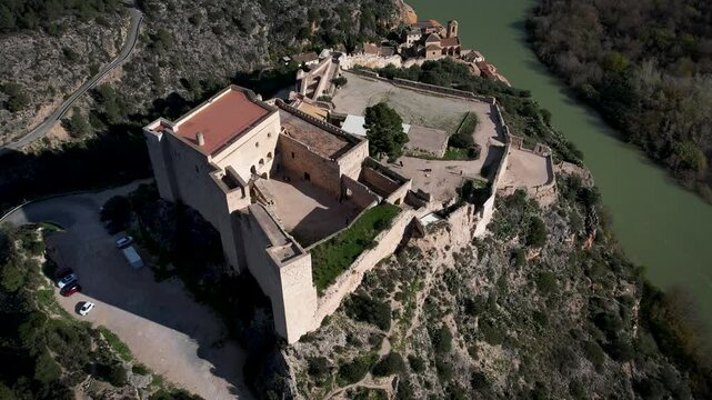 Old Miravet castle with Ebro river and Tarragona mountains on the back in Catalonia, Spain. High quality 4k drone footage