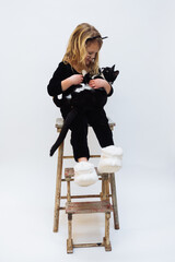 Fototapeta premium Young girl age 4-6 holding tuxedo kitten cuddling