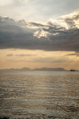 Sunset over calm sea with mountain silhouette