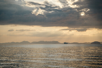 Seaside view with mountains under cloudy sky
