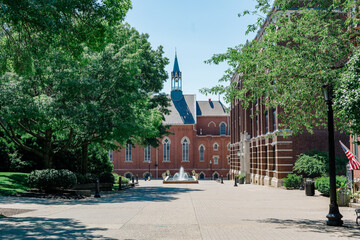 College campus with red brick church surrounded by trees and greenery.