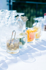 Outdoor bar setup with garnishes and glassware in natural light.
