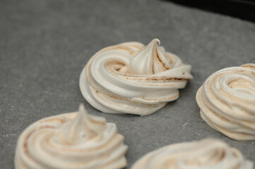 Swirls of sweetness crafted from fluffy meringue at an inviting kitchen counter during a baking session