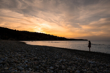 Sunset from Baia Turchina to Finale di Pollina with silhouette of girl in the background