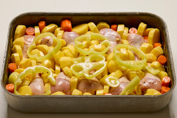 raw chicken thighs with vegetables ready to be cooked