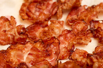 fried bacon slices placed on a paper napkin