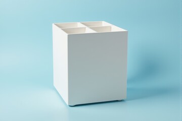 Fototapeta premium A contemporary pen stand with compartments on a pastel steel blue background