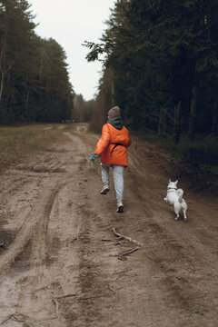 Woman running through the forest with a dog