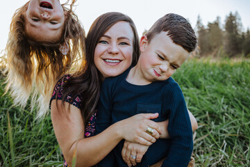 Funny family portrait of mother with her son and daughter, upside down