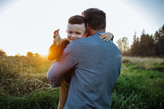 Father holding young playful boy, threatening to tickle his dad