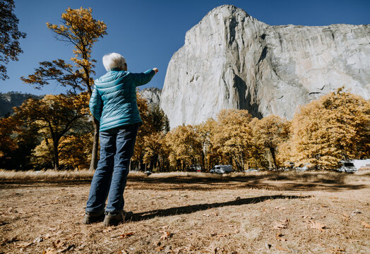 Elderly woman points at cliff of El Capitan, Yosemite Valley, CA