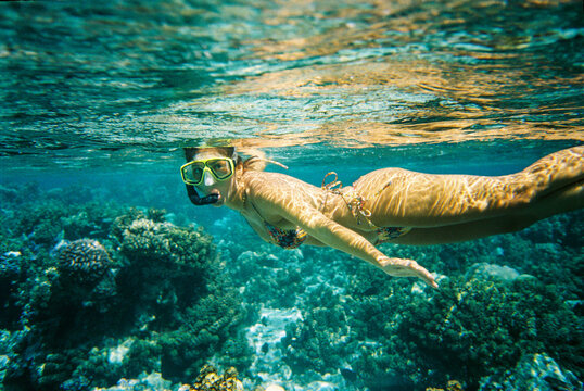 girl swimming crystal clear water over the reef of Moorea