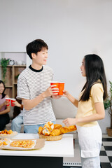Group of Young Asian friend having, enjoy evening party together at home. Attractive young man and woman having fun, eating food, celebrate at home.