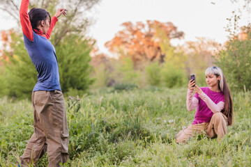 Obraz premium Two young women taking photos in nature preserve enjoying weekend