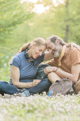 Fototapeta premium Senior couple embracing while hiking in nature, enjoying retirement