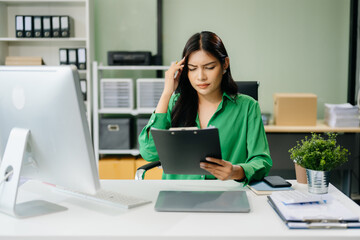 Business woman is stressed, bored, and overthinking from working on a tablet