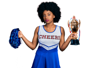 Young african american woman wearing cheerleader uniform holding pompom and trophy relaxed with serious expression on face. simple and natural looking at the camera.