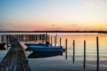 Boats resting in a tranquil harbor near Gothenburg at sunset with colorful reflections on water