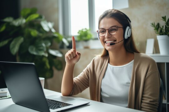Smiling customer service representative raising finger while working on laptop