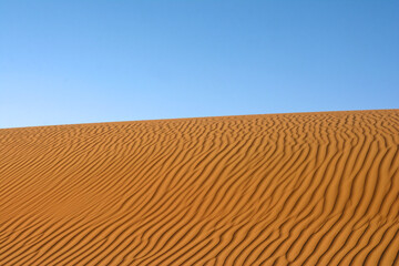 Sunset over the desert of Al Khatim in Abu Dhabi, Emirates. Golden Sand Dune Desert Landscape Panorama. Beautiful sunset over the sand dunes