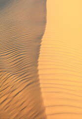 Sunset over the desert of Al Khatim in Abu Dhabi, Emirates. Golden Sand Dune Desert Landscape Panorama. Beautiful sunset over the sand dunes