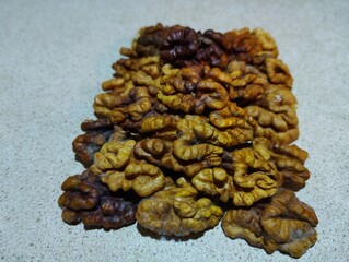 Walnut kernels piled up on a gray background. Food and healthy food and ingredients theme.