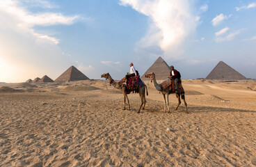 Great Pyramids of Giza - couple riding camels on the desert