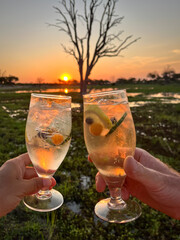 Sundowner on safari with two glasses of non-alcoholic rock shandy at sunset