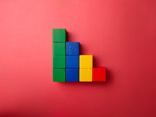 Obraz premium Colorful wooden blocks creating a decreasing graph on red background