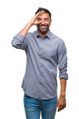 Fototapeta premium Adult hispanic man over isolated background doing ok gesture with hand smiling, eye looking through fingers with happy face.