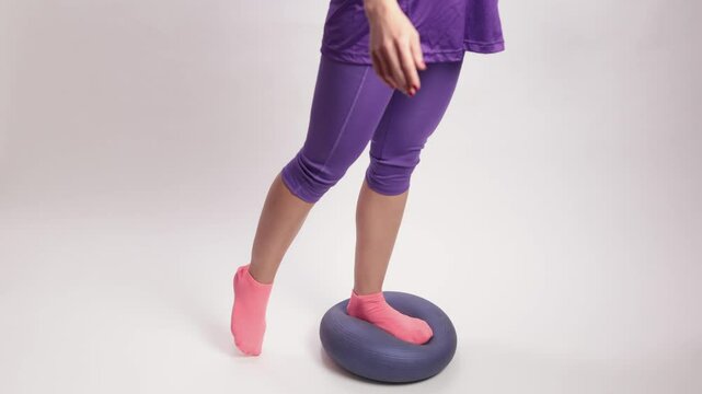 Latin woman balancing on bosu ball ankle proprioception exercises on white background