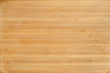 A light brown bamboo cutting board with visible grain and fibers