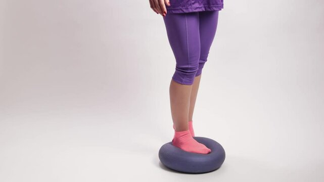 Latin woman balancing on inflatable BOSU ball ankle proprioception exercises