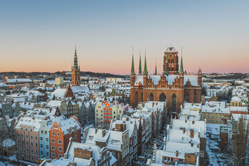 Fototapeta premium Gdańsk with a view of St. Mary's Basilica in the winter morning. Snow on the roofs of tenement houses and streets.